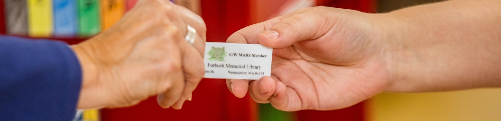 Photo of people exchanging a Library card